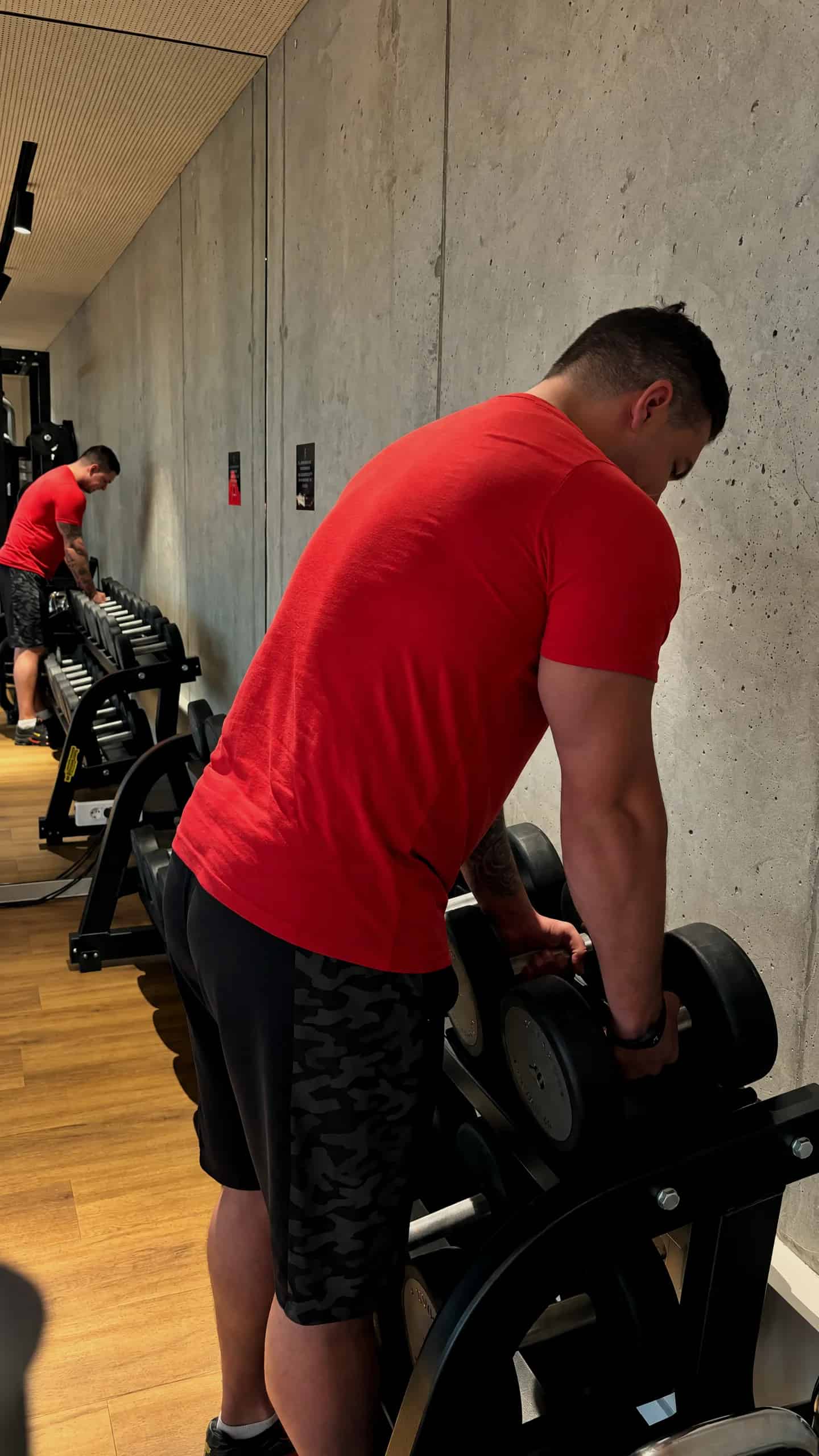 Luka Bogadi pri stojalu z ročkami v fitnesu